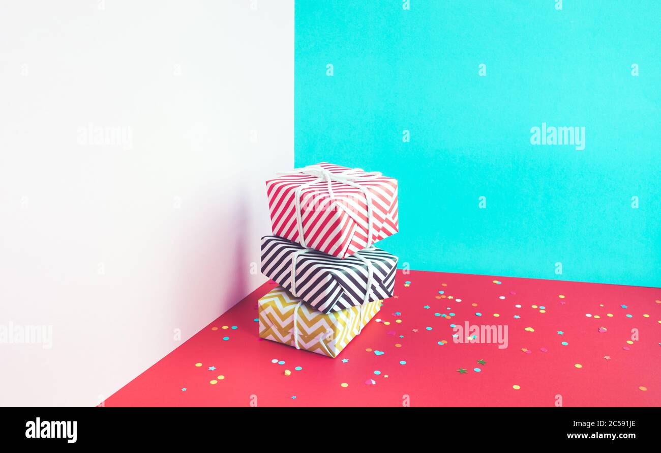 Festa di anniversario e concetti di partito idee con colorati confezione regalo presente e coriandoli elemento sul colore blu di sfondo.Vista dall'alto del modello di progettazione Foto Stock
