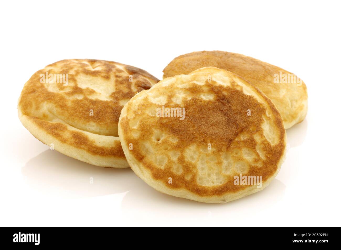 Mini pancake olandesi tradizionali appena sfornati chiamati "poffertjes" con zucchero in polvere su sfondo bianco Foto Stock