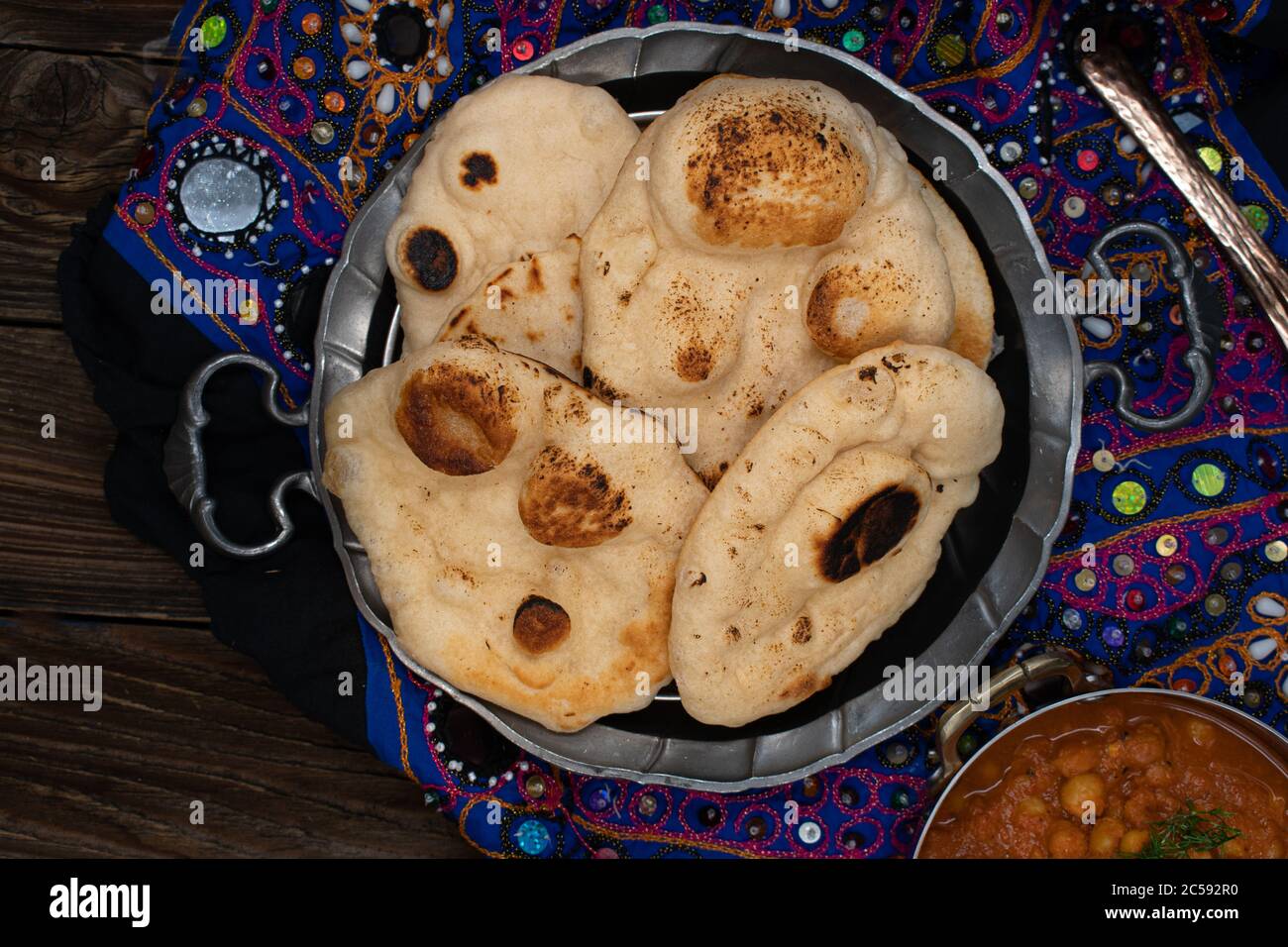 Pane indiano mini naan in piastra metallica su sfondo di legno Foto Stock