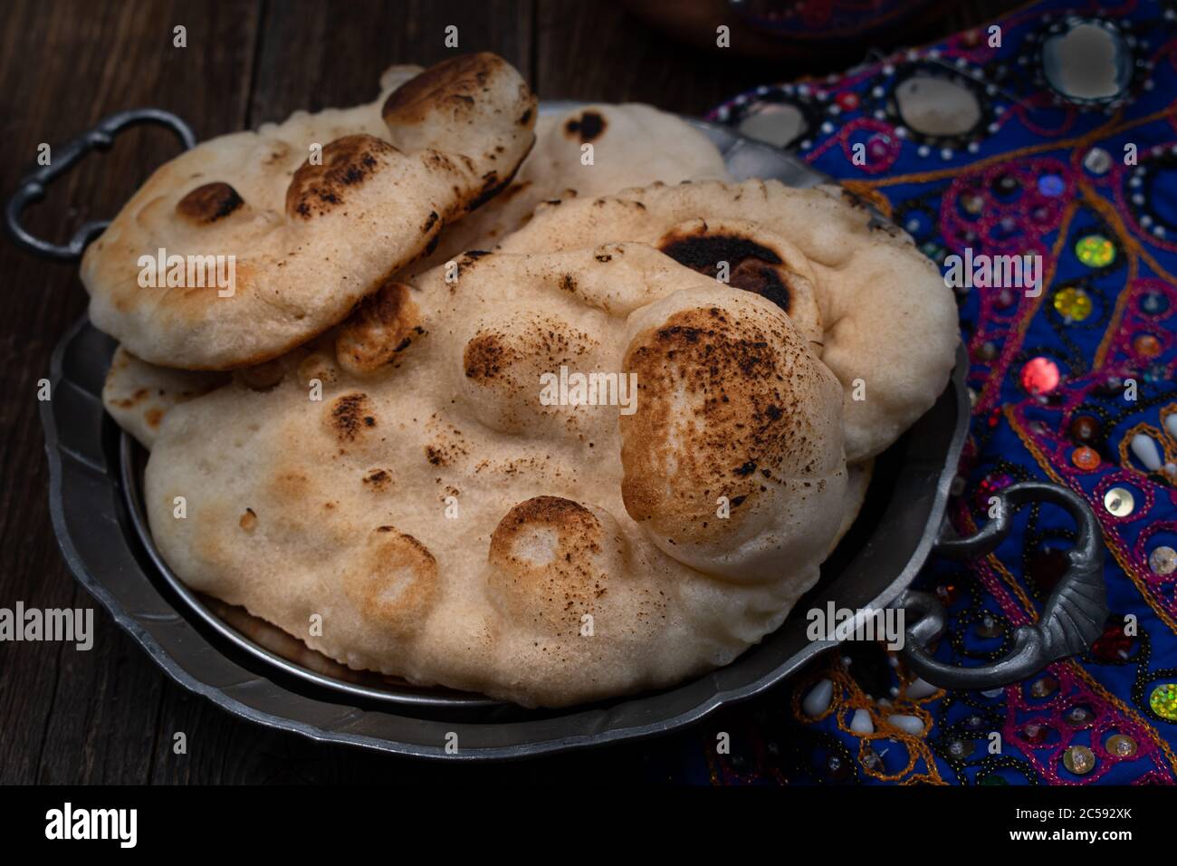 Pane indiano mini naan in piastra metallica su sfondo di legno Foto Stock