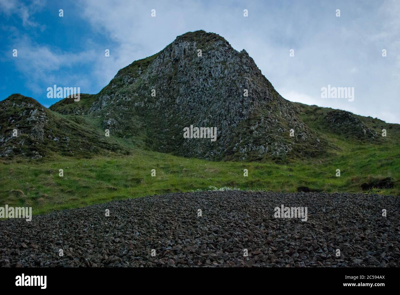 Vista su una montagna in mezzo all'erba verde Foto Stock