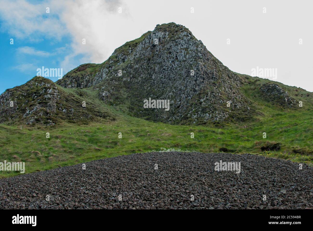 Vista su una montagna in mezzo all'erba verde Foto Stock
