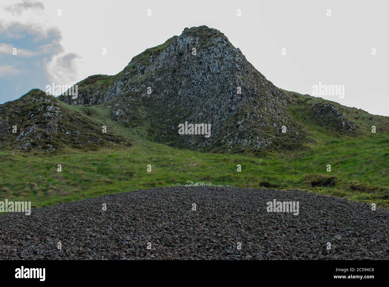 Vista su una montagna in mezzo all'erba verde Foto Stock