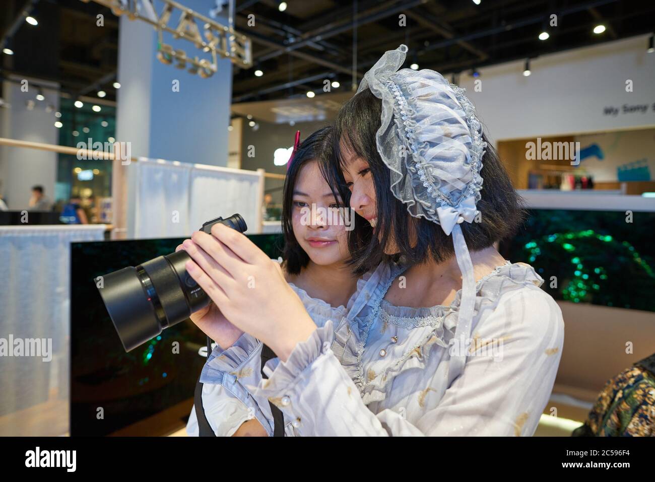 SHENZHEN, CINA - CIRCA APRILE 2019: Le donne cinesi visualizzano le immagini sulla fotocamera nel Sony Store di UpperHills durante il Sony Expo 2019. Foto Stock