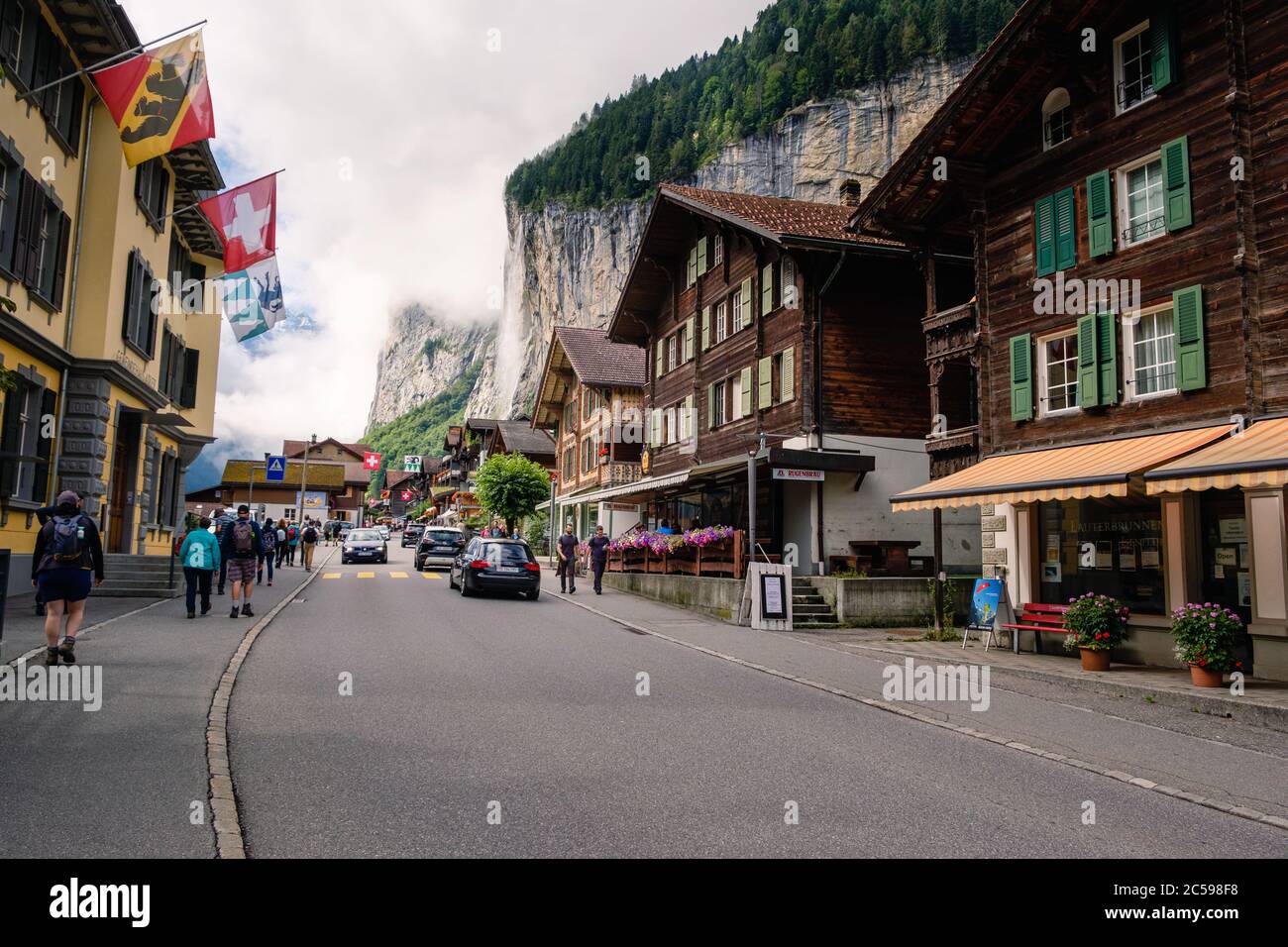 Lauterbrunnen, Berner Oberland, Svizzera - Luglio 29 2019 : i turisti passeggiano nella suggestiva strada principale del pittoresco villaggio svizzero nel Ju Foto Stock