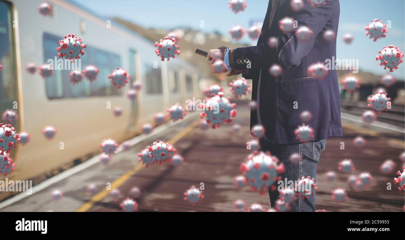 Covid-19 celle contro l'uomo che usa smartphone alla stazione ferroviaria Foto Stock