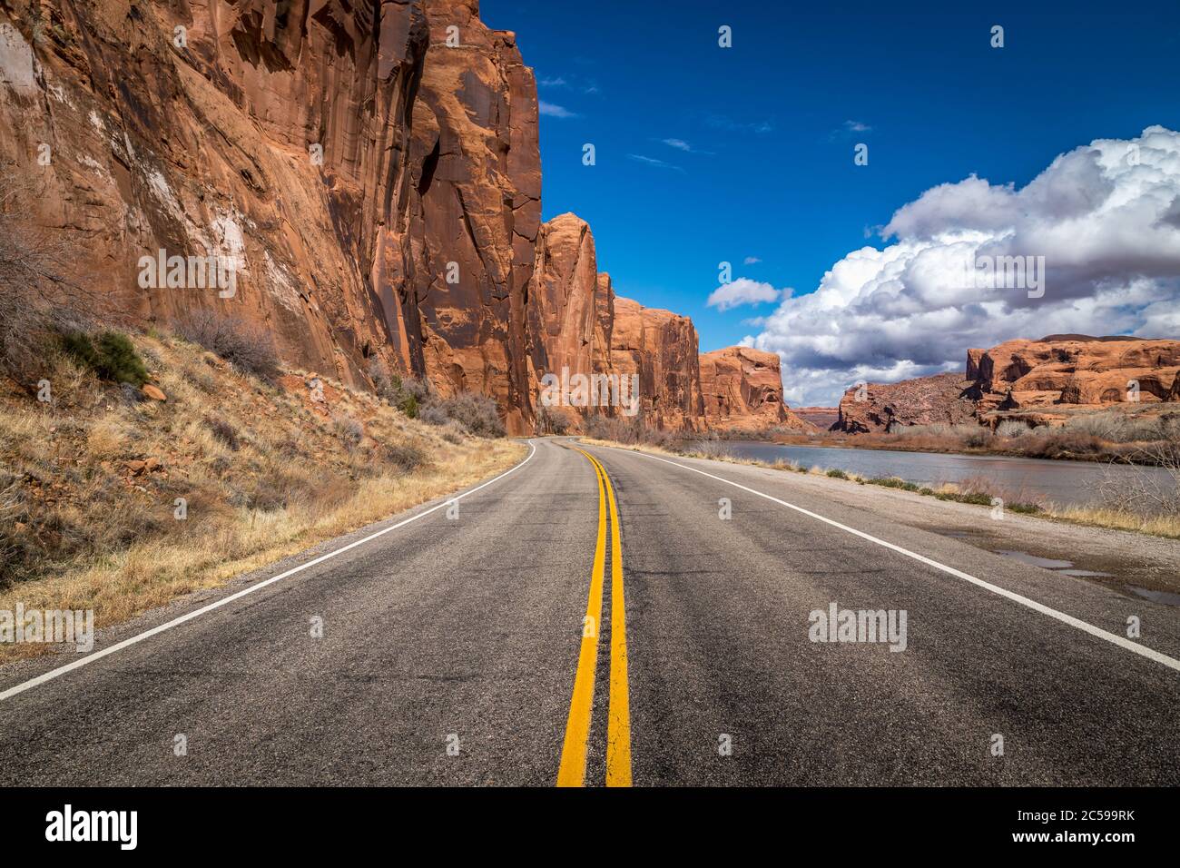 Vista colorata dalla Utah Scenic Byway 279 con alte scogliere di arenaria su un lato e il fiume Colorado sull'altro, Moab, Utah Foto Stock