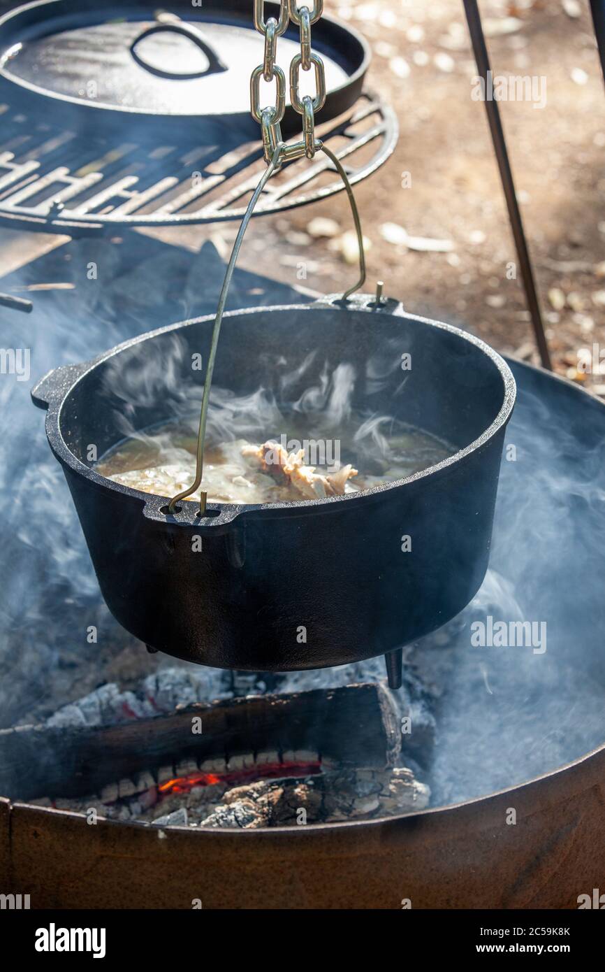 Brodo di pollo fumante cotto su fuoco a legna aperto Foto Stock