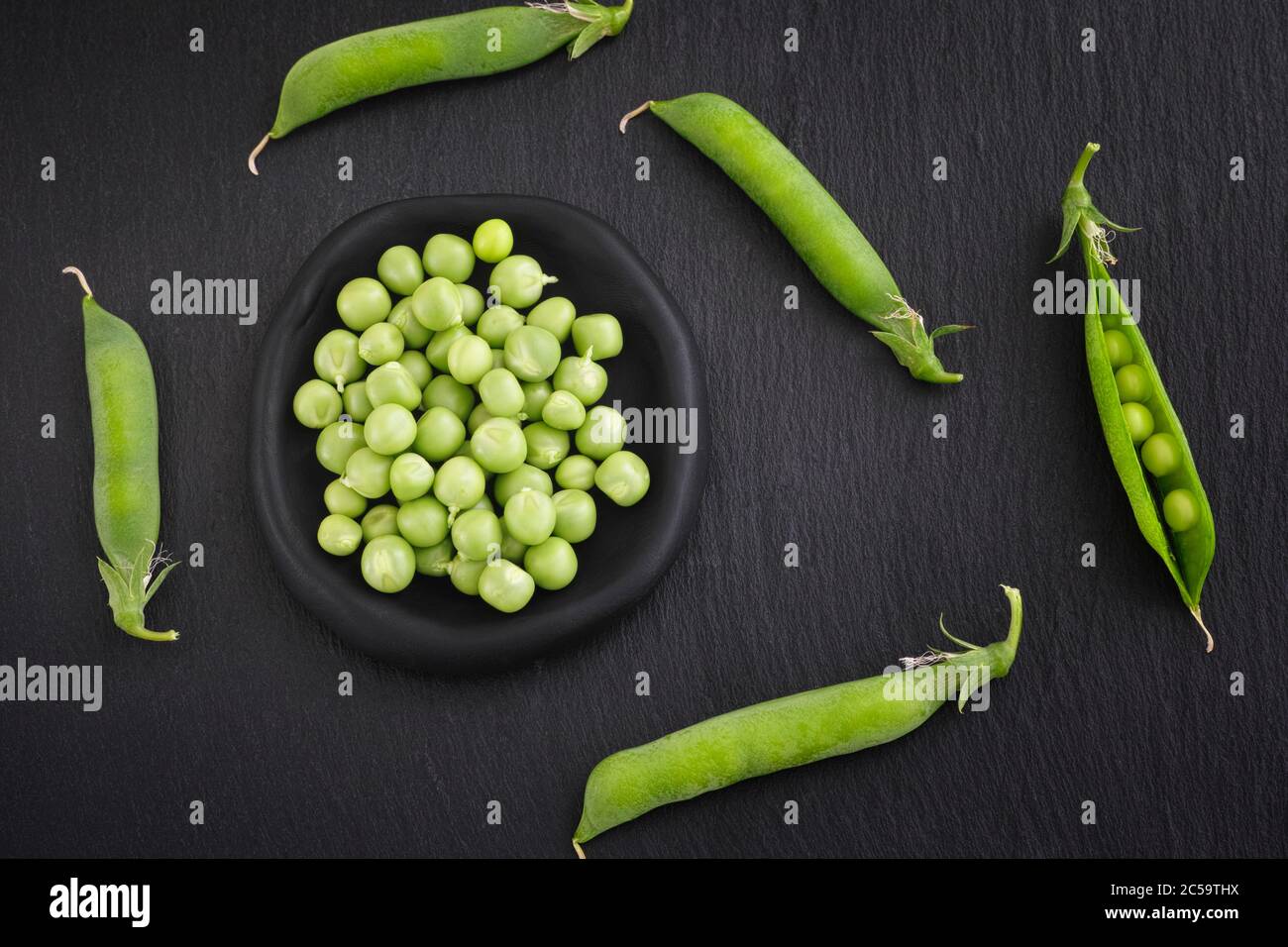 Piselli verdi in un recipiente nero. Primo piano. Foto Stock