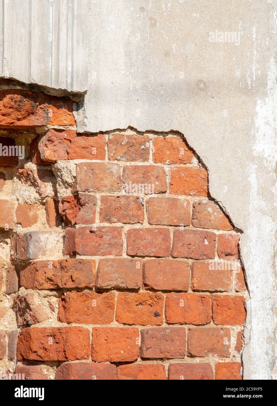 Un frammento di una parete di mattoni con la vernice che si stacca. Foto Stock