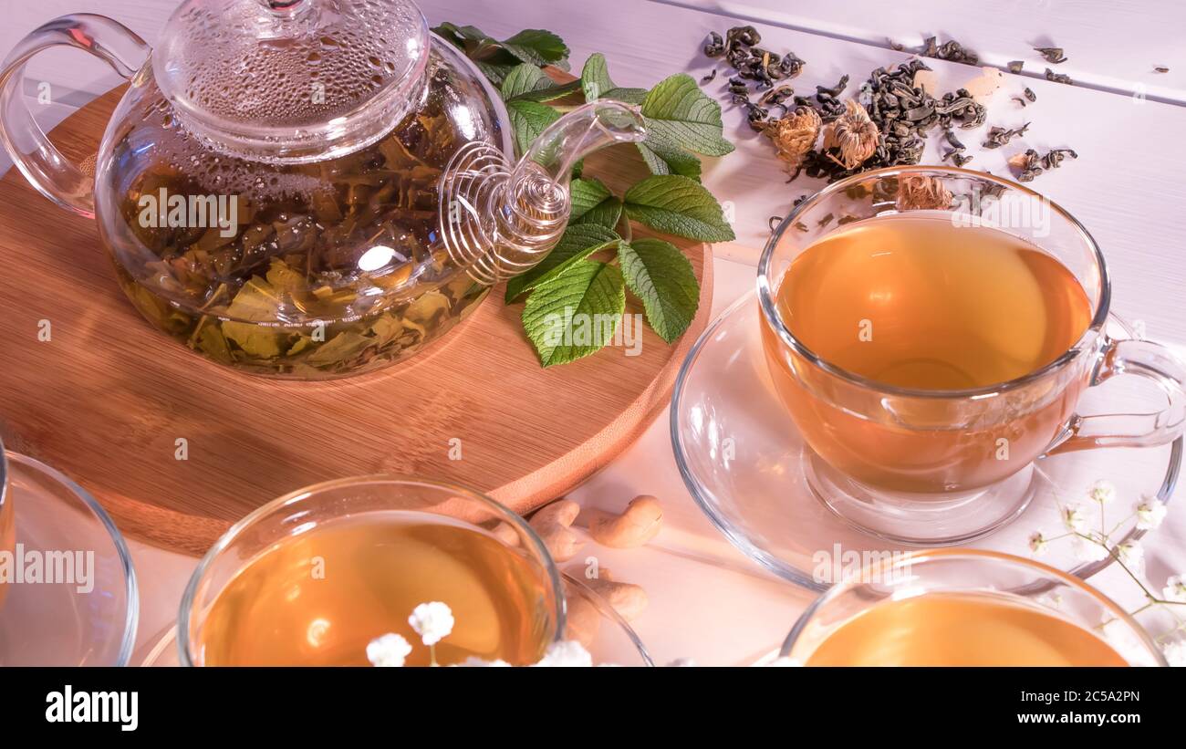 Una tazza di tè verde e una teiera. Tè floreale con fette di frutta. Cerimonia del tè, bevanda tradizionale. Tè pomeridiano, casalinga. Disposizione piatta. Orientale, accogliente, pre Foto Stock