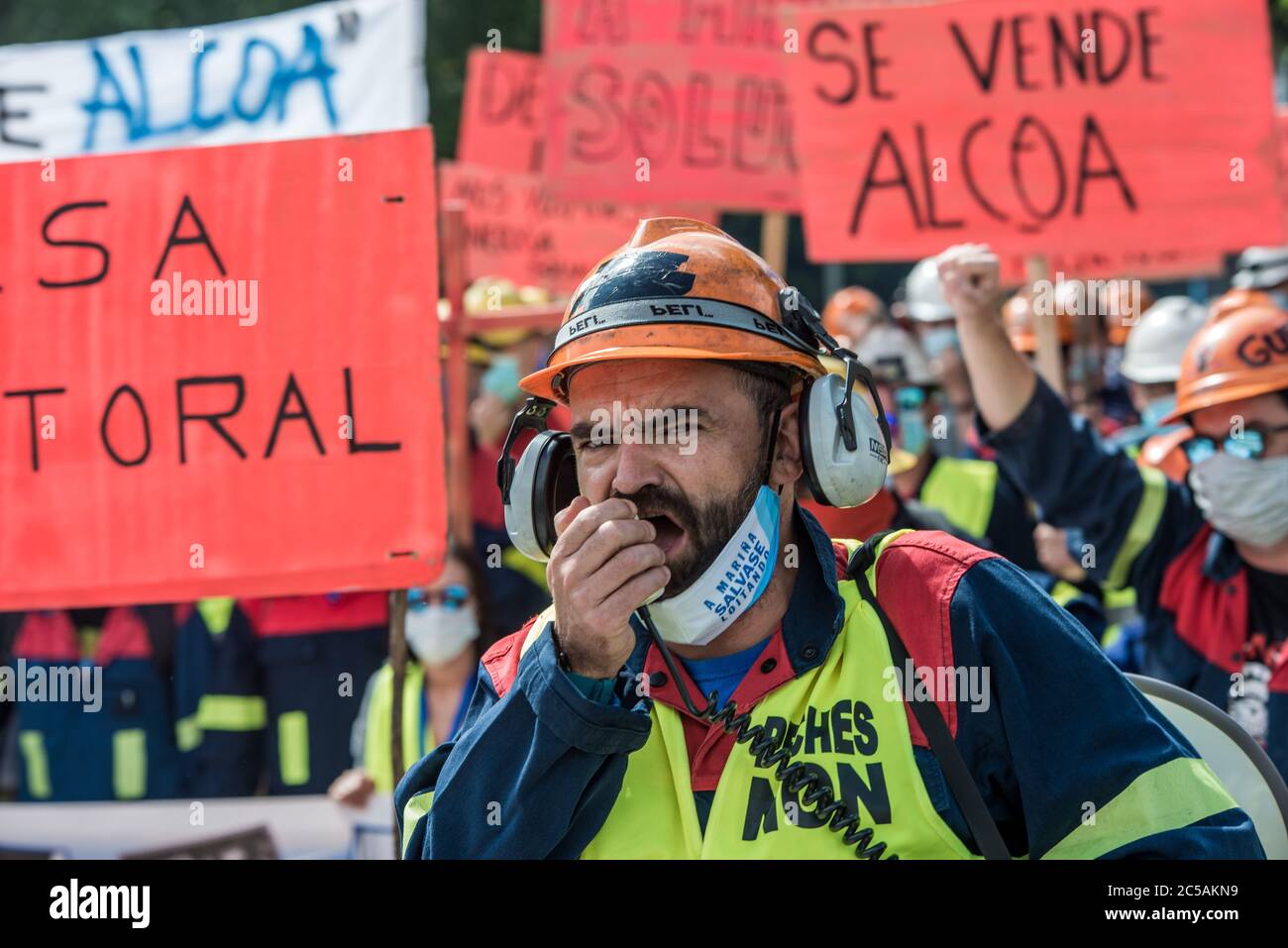 Un operaio Alcoa urlò su un megafono durante la dimostrazione.migliaia di persone marciarono a Santiago de Compostela presso il governo regionale a seguito delle manifestazioni del consiglio d'opera di Alcoa che iniziarono un mese fa contro il licenziamento collettivo di un massimo di 534 lavoratori dalle sue due fabbriche a San Cibrao. La manifestazione è segnata dalla vicinanza delle elezioni del 12 luglio del governo regionale della Galizia. Foto Stock