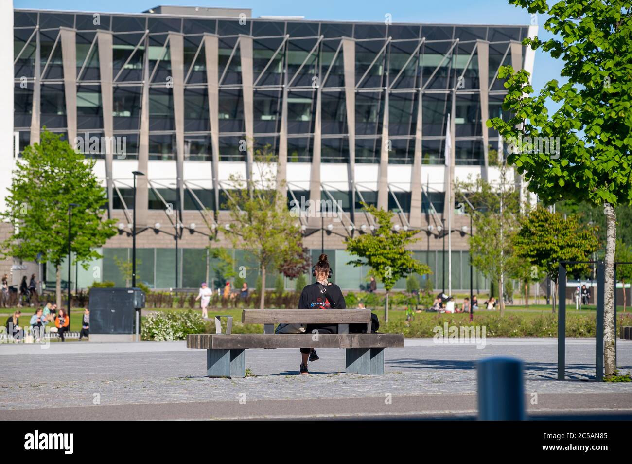 Helsinki / Finlandia - 2 GIUGNO 2020: Una donna seduta nel parco dopo le misure di blocco pandemiche in Finlandia sono state revocate il 1° giugno 2020. Foto Stock