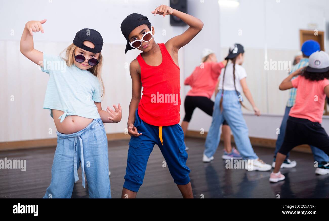 Presuera ragazza e ragazzo in cappelli e occhiali da sole che eseguono hip- hop alla classe di ballo di gruppo Foto stock - Alamy