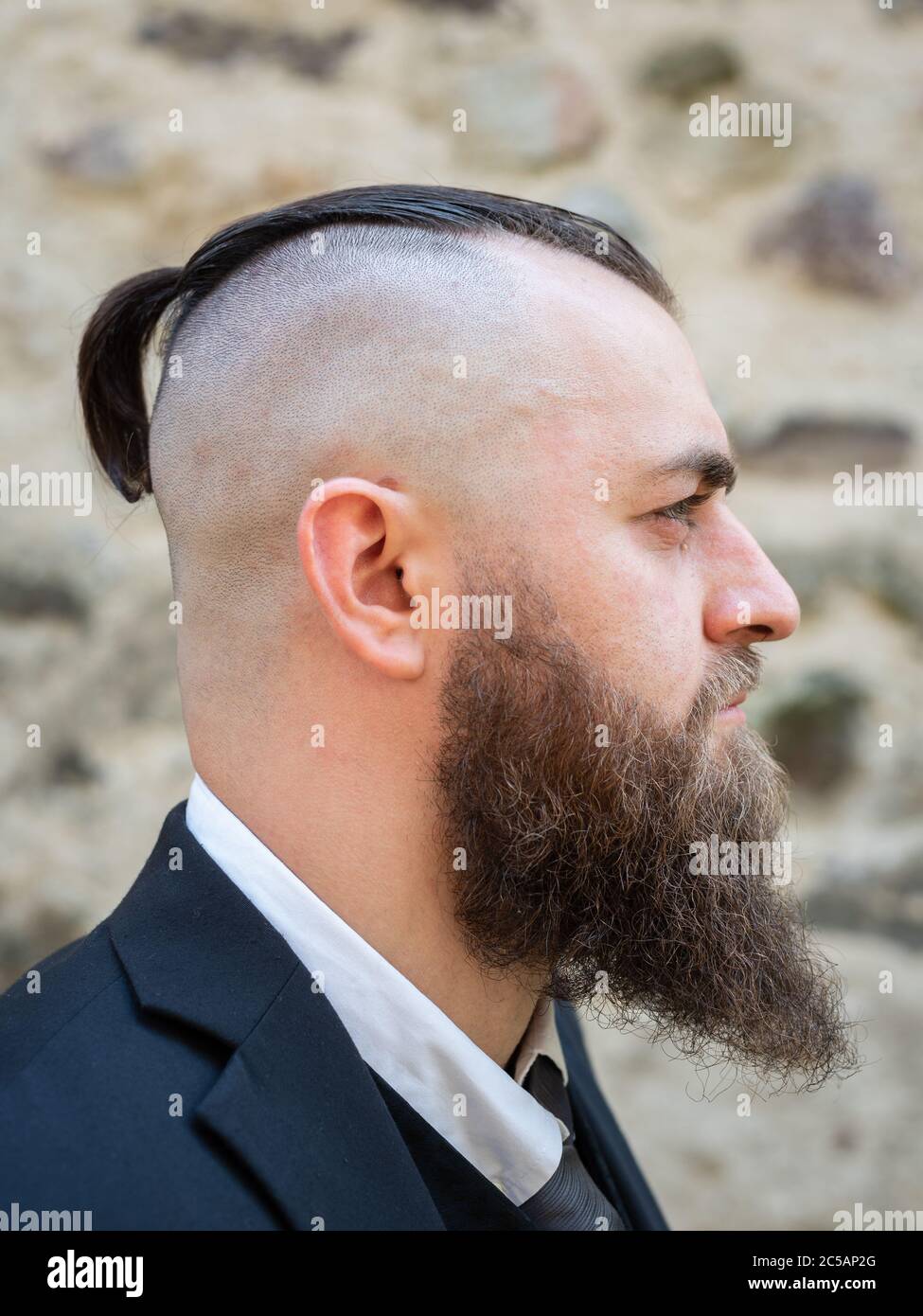 Ritratto di un uomo con barba lunga e un taglio corto in abiti eleganti Foto Stock