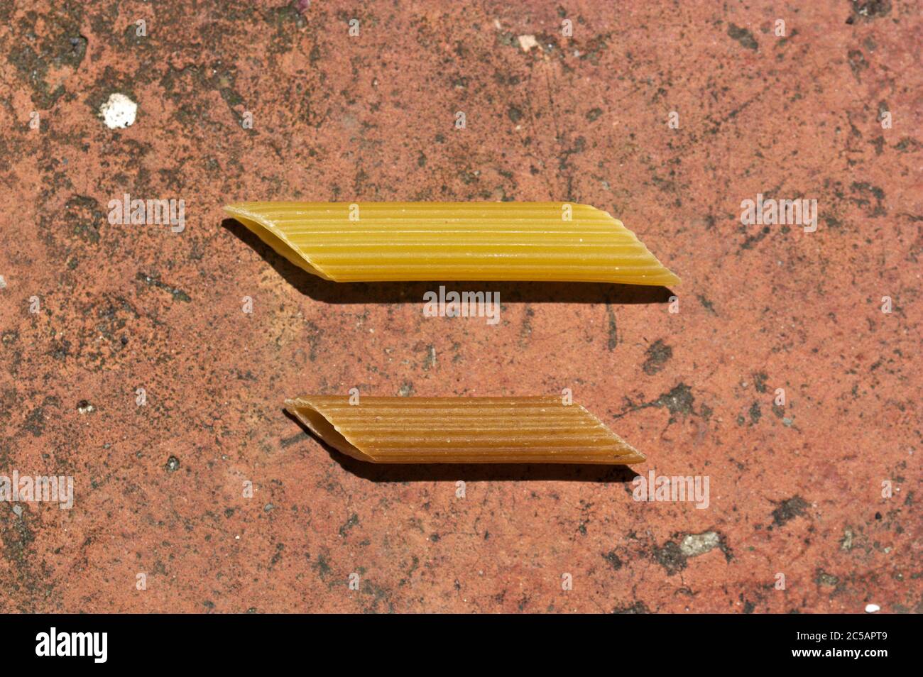 Primo piano di due macaroni, uno normale e uno più piccolo integrale su un fondo grunge Foto Stock