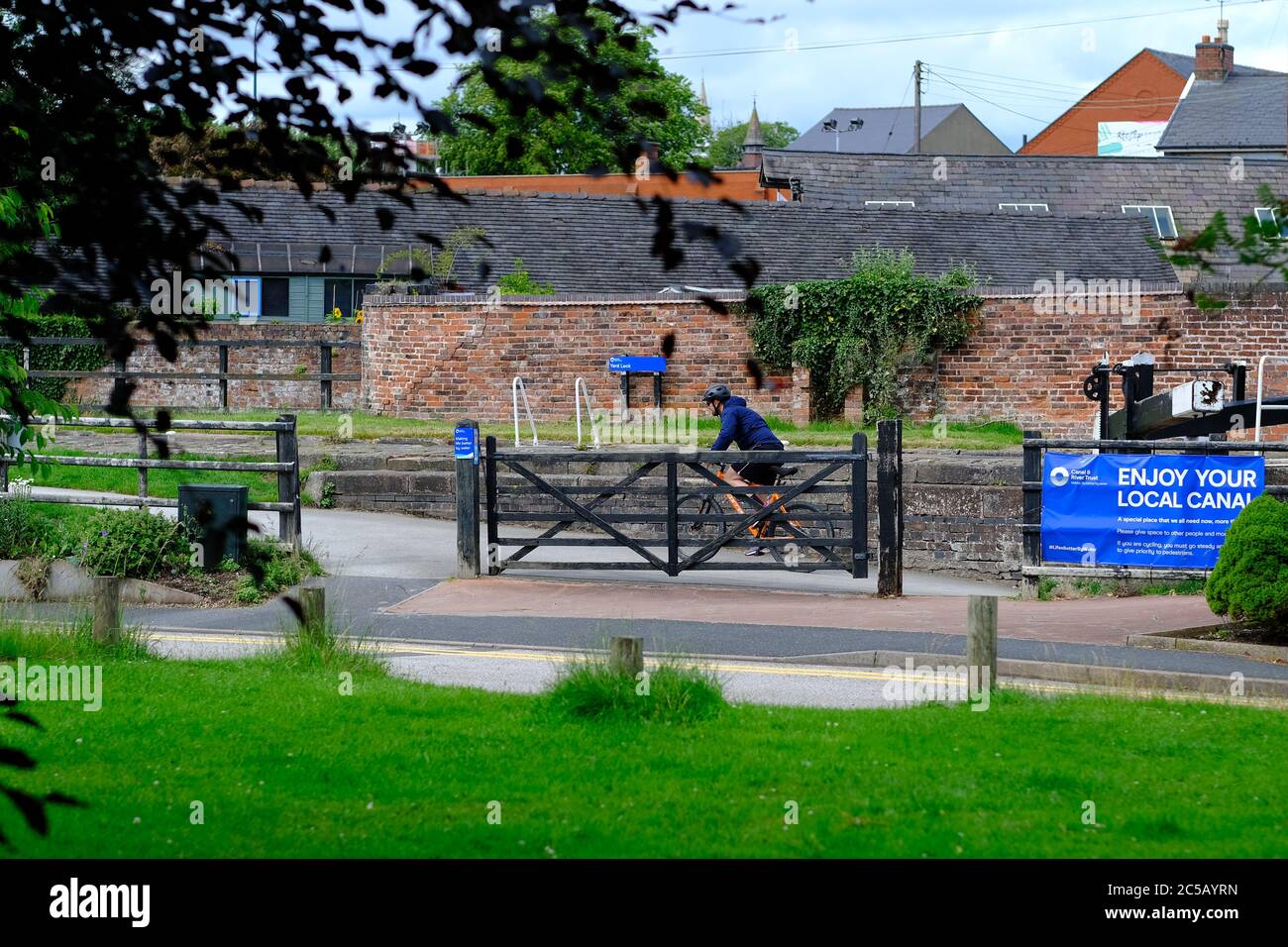 Blocco facilitato. Ciclista sulla bici accanto al blocco del canale Trent e Mersey a Stone, Staffordshire, Regno Unito. Ascensore di quarantena. Foto Stock