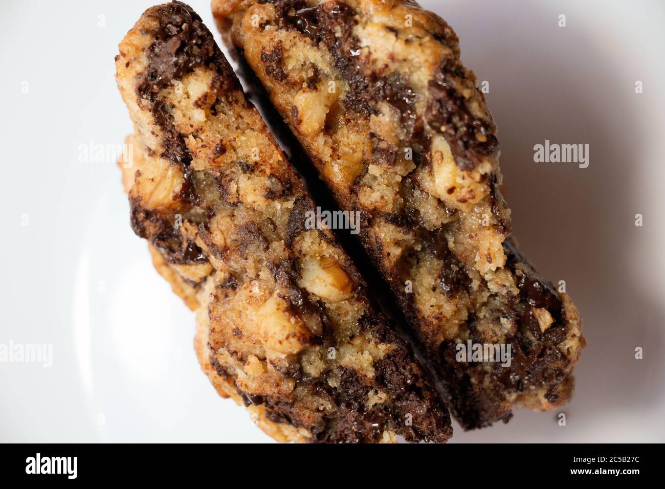 Primo piano dell'interno di due fette di biscotti di farinata d'avena al cioccolato su sfondo bianco Foto Stock