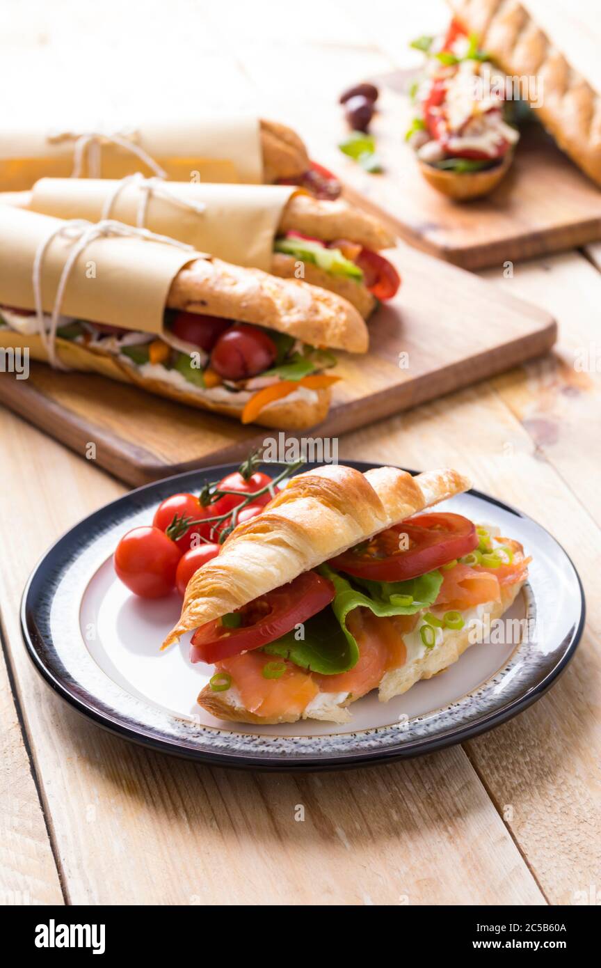 Panini freschi sottomarini con varietà di ripieni su sfondo di legno Foto Stock