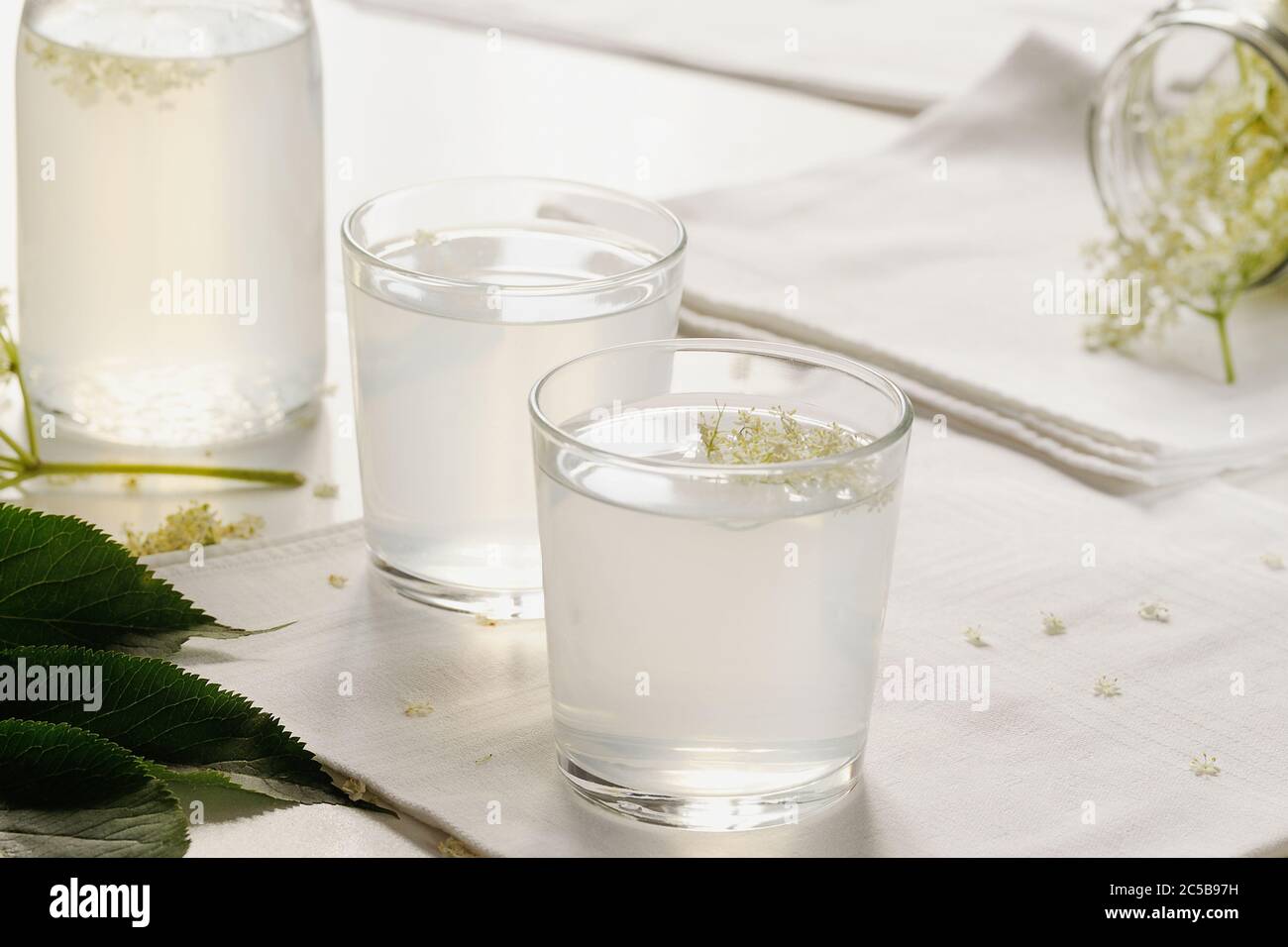 Bevanda estiva fatta con fiori di sambuco sirop e limone su sfondo bianco.orizzontale con spazio per il testo. Foto Stock