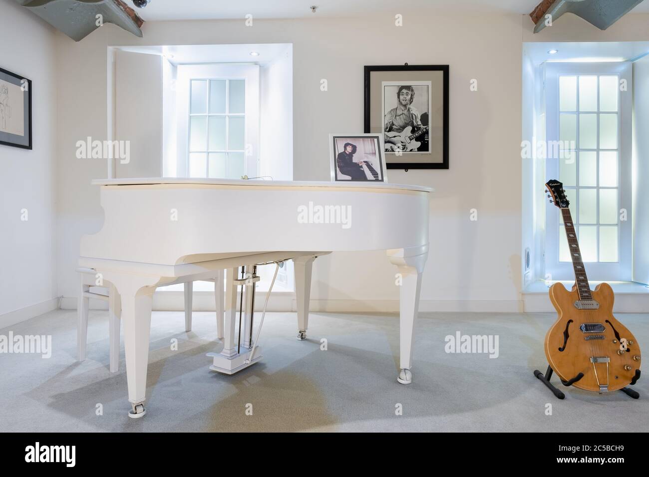 Sala con il famoso pianoforte bianco utilizzato per suonare Imagine e una  chitarra di proprietà di John Lennon alla mostra Beatles Story di Liverpool  Foto stock - Alamy