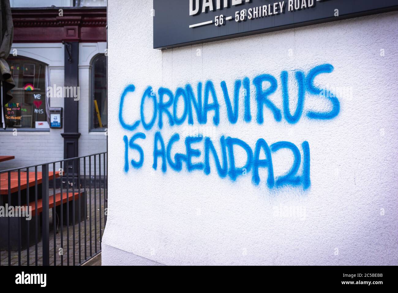 "Il coronavirus è Agenda 21" teoria della cospirazione slogan politico graffiti scritti su un muro bianco a Southampton, concetto di disinformazione, Inghilterra, Regno Unito Foto Stock