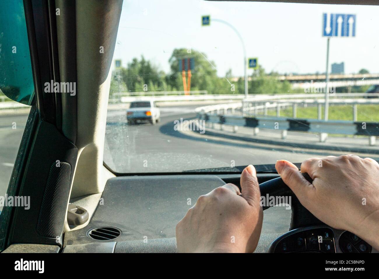 cambio di auto vista laterale di un conducente di una macchina, sul volante mani non ben curate di una donna di mezza età Foto Stock