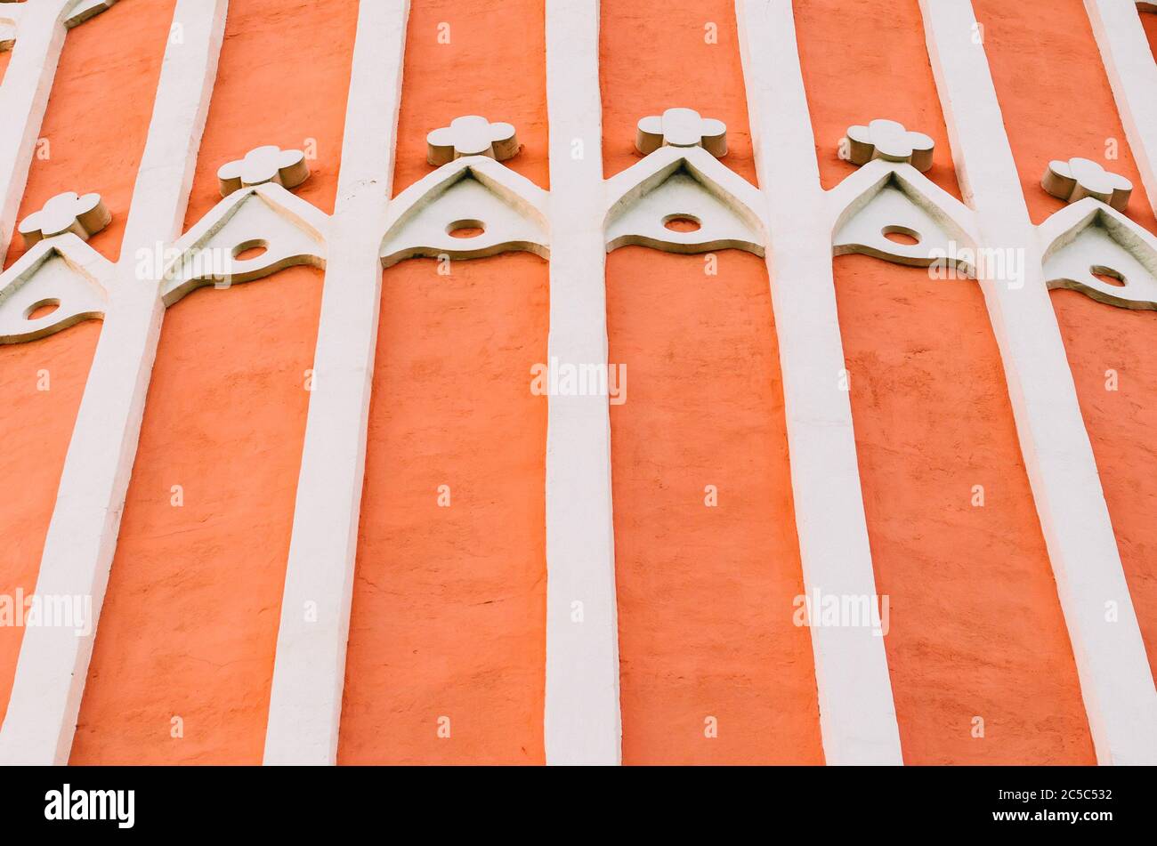 Strisce bianche ed elementi di architettura vintage su una parete rossa Foto Stock