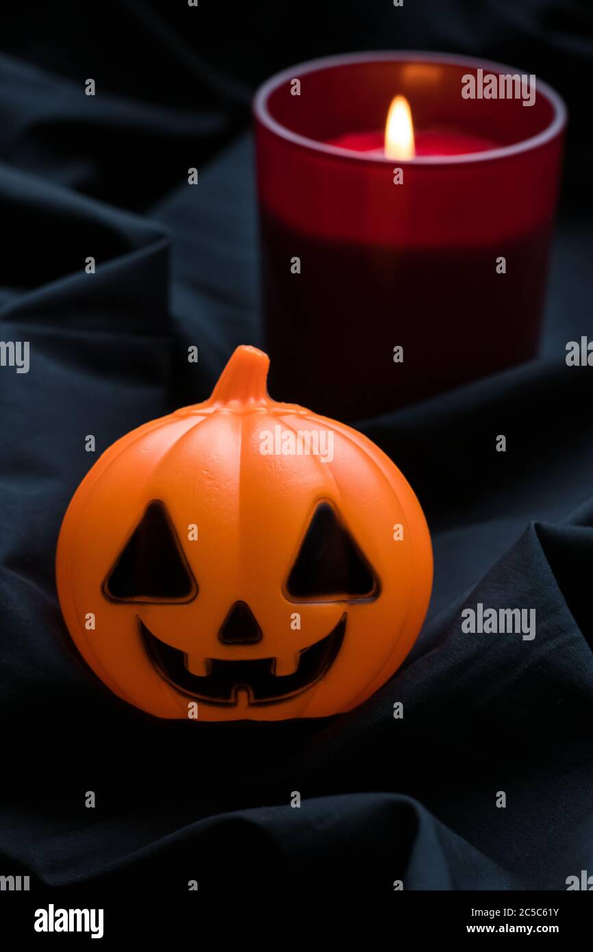 Zucca di Halloween con candela rossa su sfondo scuro. Jack o lanterna. Buono regalo per le feste, decorazioni per le feste. Festa cristiana occidentale di tutto Hallo Foto Stock