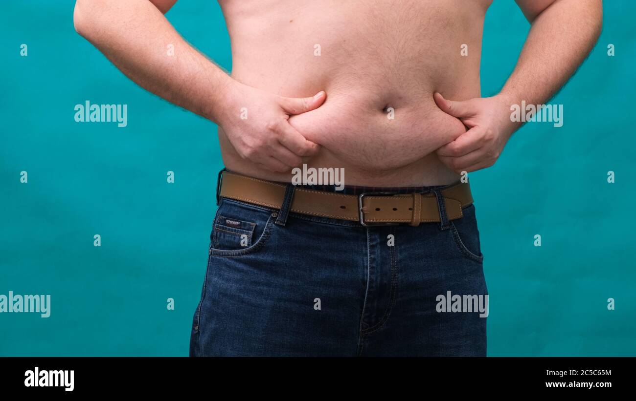 l'uomo con un pancia grande mostra il suo grasso. Il concetto di  alimentazione sana e peso perdente, dieta Foto stock - Alamy