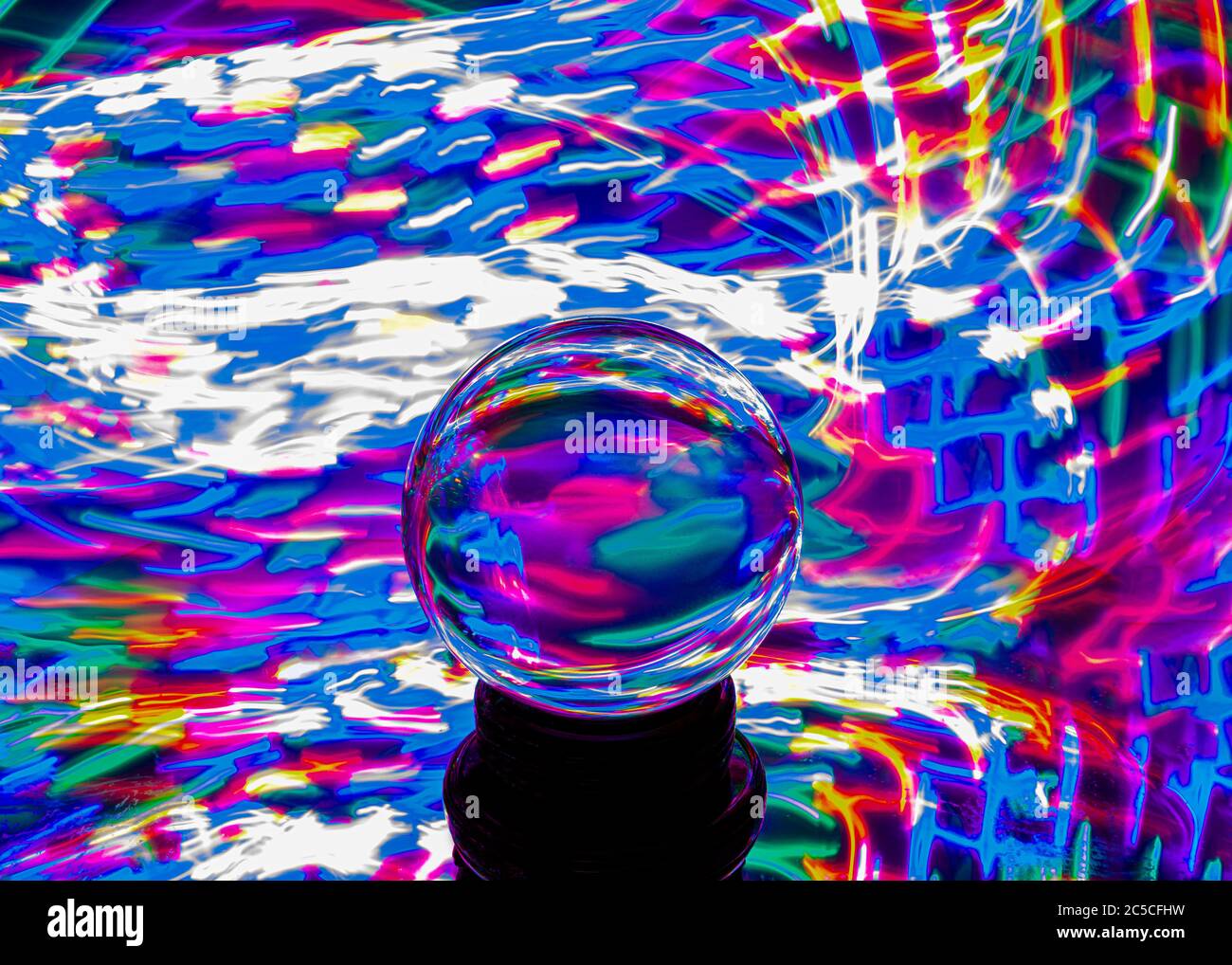 Una palla di cristallo circondata da colori psichedelici Foto Stock