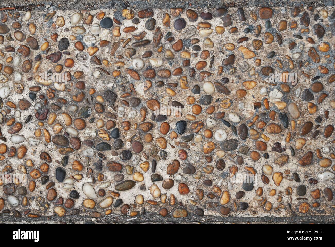 pile di pietre di ghiaia colorate su pavimento di cemento. sfondo e struttura per il vostro disegno Foto Stock