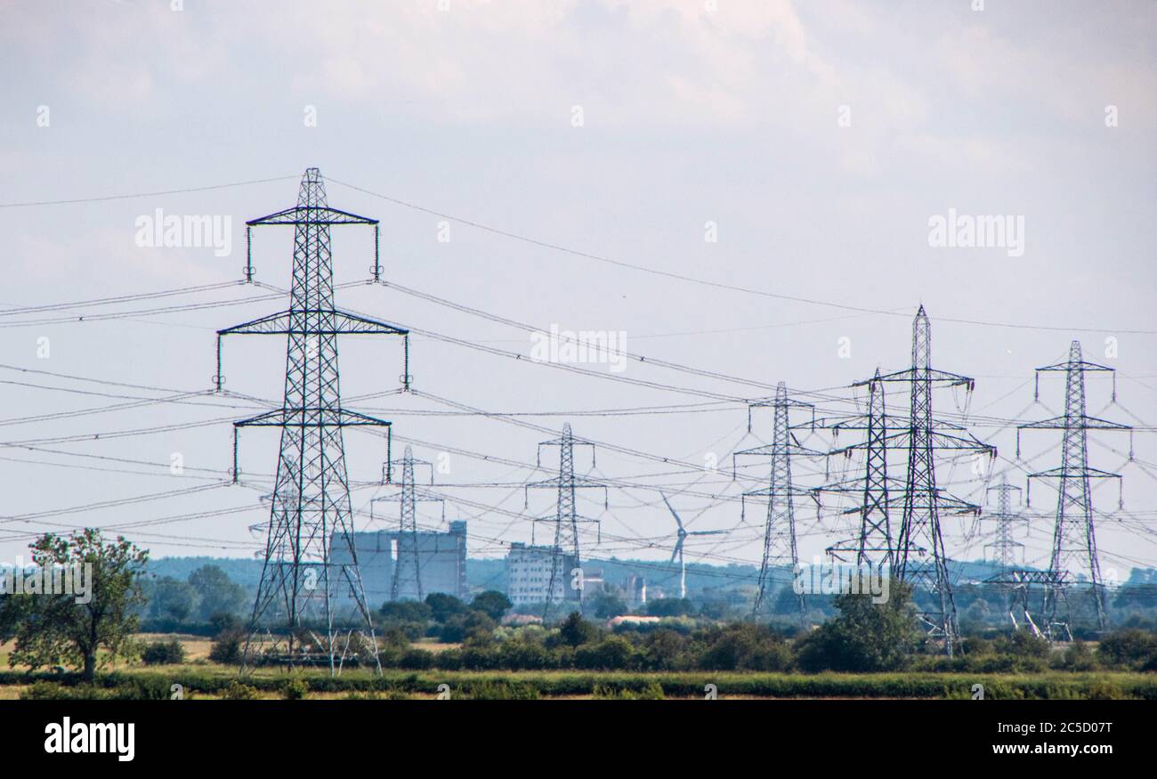 Una fila di piloni di elettricità si dipanano attraverso la campagna nel Regno Unito. Foto Stock