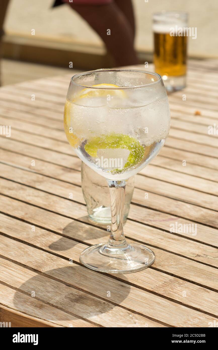 tonico gin una tazza di vetro in un tavolo di legno in spiaggia per godersi  una giornata di sole Foto stock - Alamy