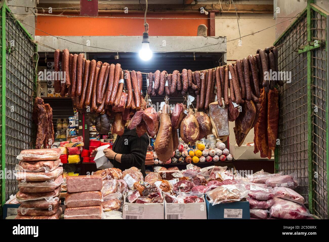 SUBOTICA, SERBIA - 28 MARZO 2019: Salsicce secche, chiamate Kulen kobasica e altri salumi appesi su una bancarella nel mercato di Subotica, chiamato bu Foto Stock