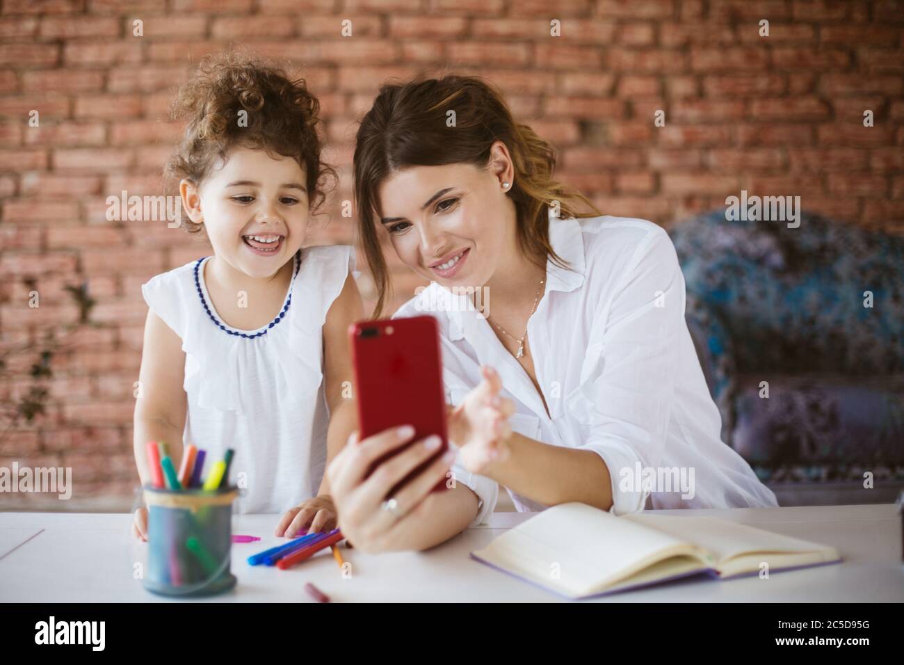 Bella giovane madre e la sua gioiosa figlia del bambino, felicemente taki Foto Stock