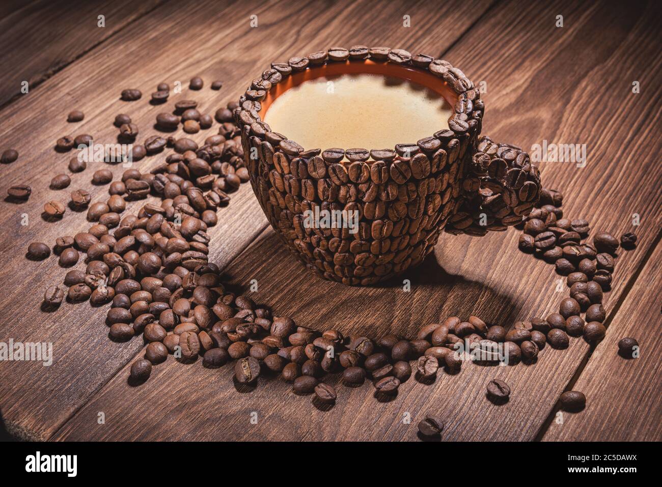 Tazza di caffè con caffè ottenuto da caffè in grani tavolo di legno. Primi piani tazze. Caffè naturale in grani arabica. Coffee Cup Table Tree Coffee Grain vista laterale Foto Stock