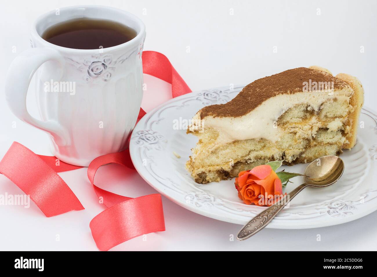 pezzo di tiramisù su un piatto bianco, una tazza di tè Foto Stock