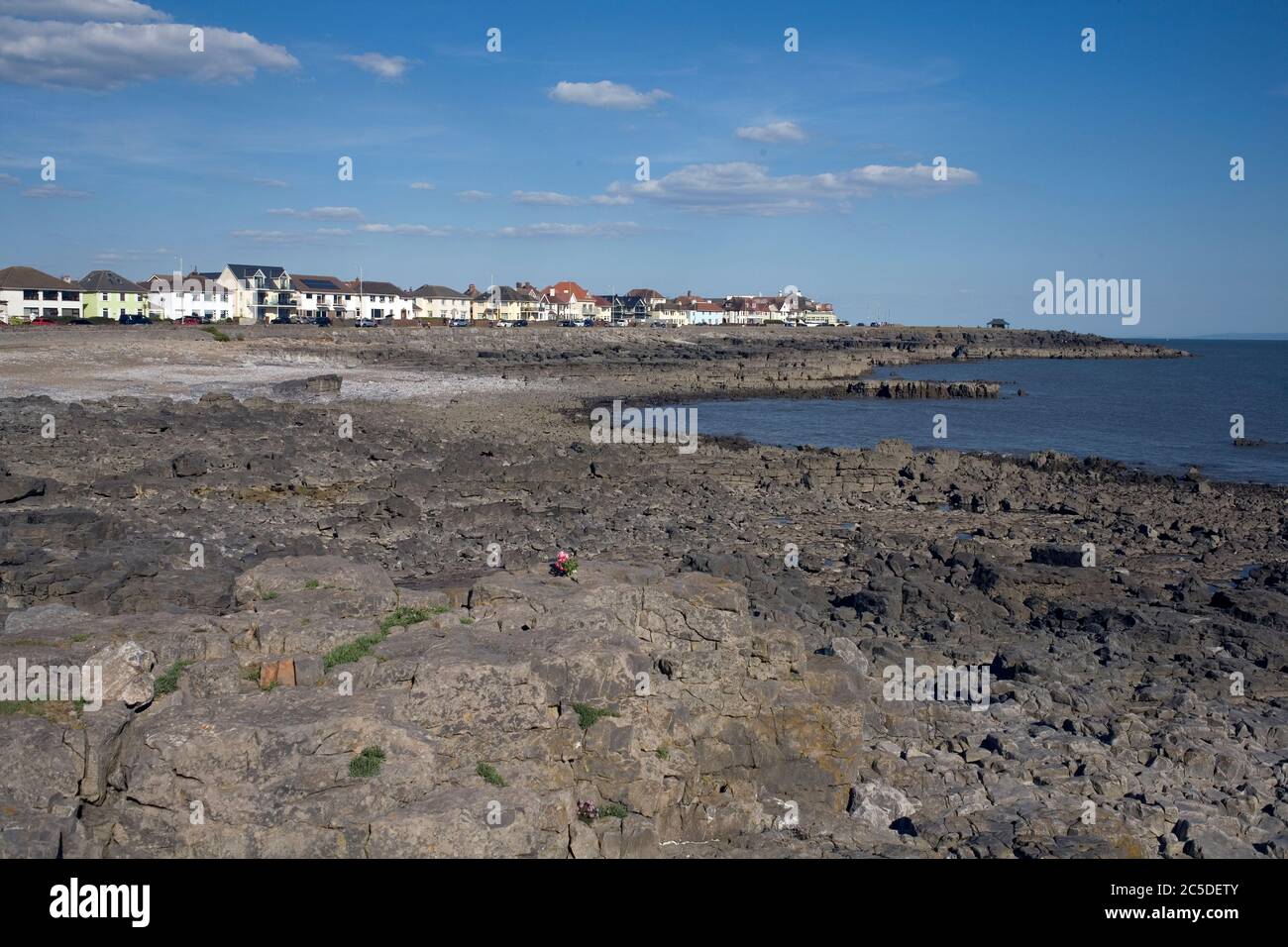 Porthcawl lungomare in West Drive con il primo piano roccioso nel tardo pomeriggio in una calda giornata estiva Foto Stock