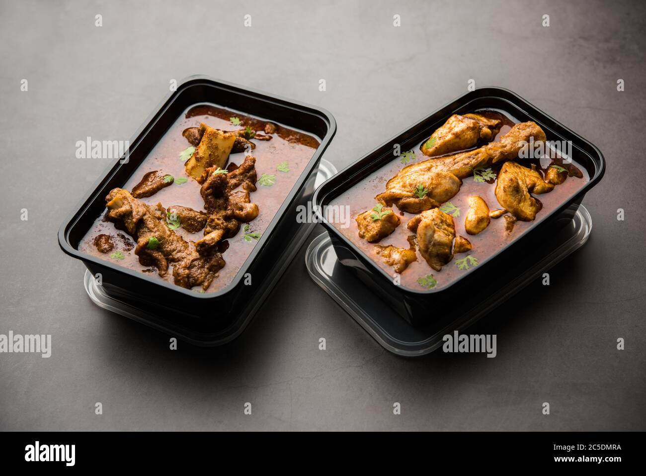 Pollo rosso curry e Mutton Masala imballati in un contenitore di plastica per la consegna Foto Stock