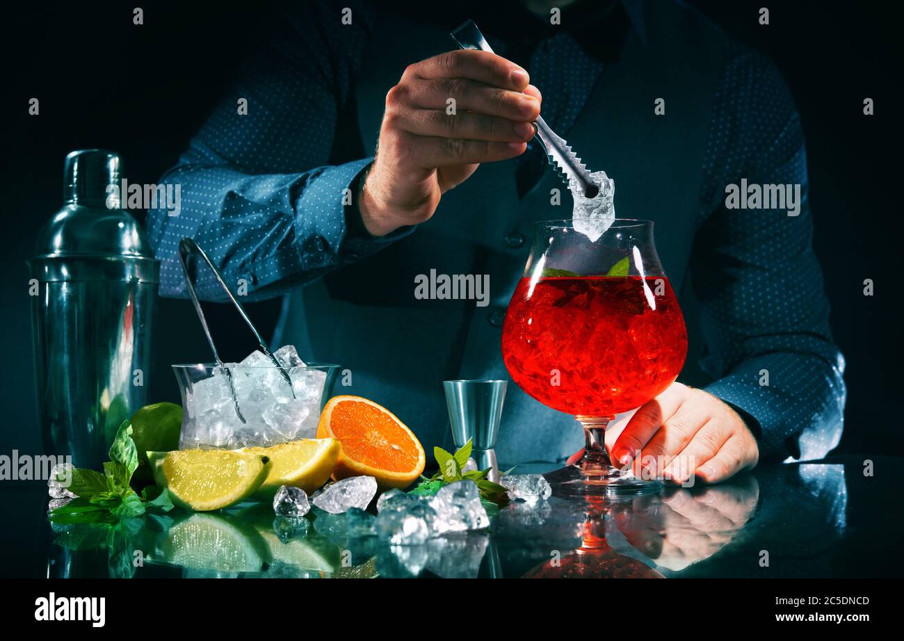 Il barman sta facendo un cocktail arancione campari al night club Foto Stock