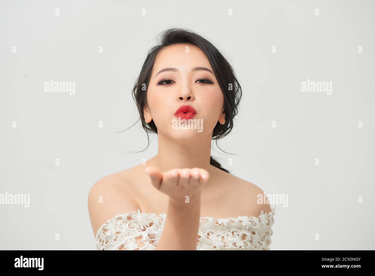 Sposa asiatica con faccia d'anatra che invia bacio d'aria isolato su bianco Foto Stock