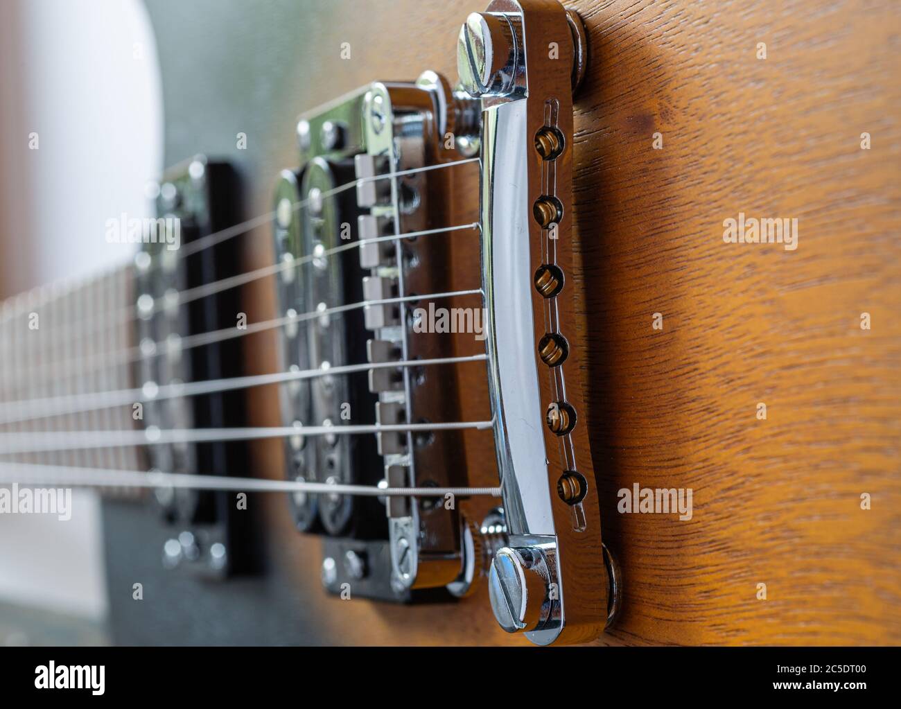 Corpo elettrico della chitarra. Strumento musicale in legno. Dettagli chitarra. Ponte di chitarra con corde. Foto Stock