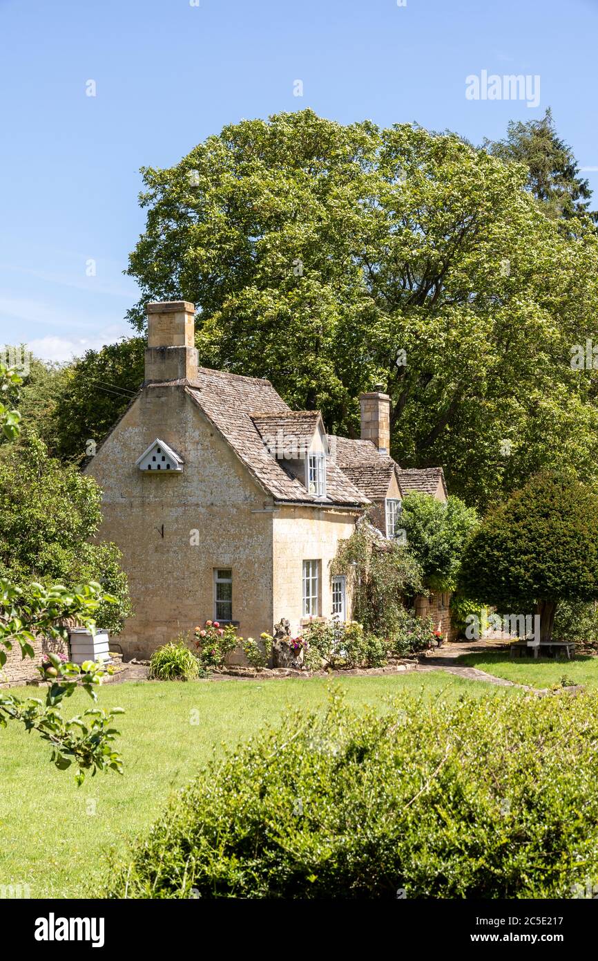 Un tipico cottage in pietra accanto alla strada Winchcombe sulle colline Cotswold vicino alla frazione di Farmcote, Gloucestershire UK Foto Stock