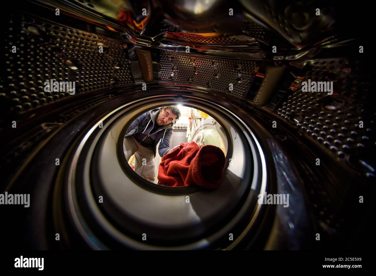 L'uomo che fa lavanderia. Vista dall'interno della lavatrice. Foto Stock