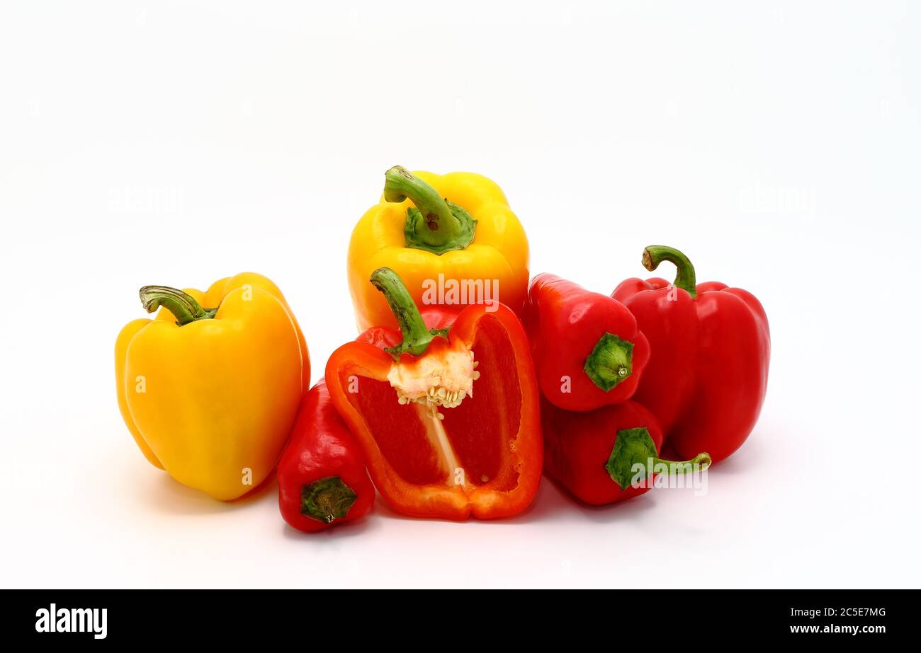 Composizione di diversi peperoni dolci e delle loro metà di colori diversi su uno sfondo chiaro. Prodotto naturale. Colore naturale. Primo piano. Foto Stock