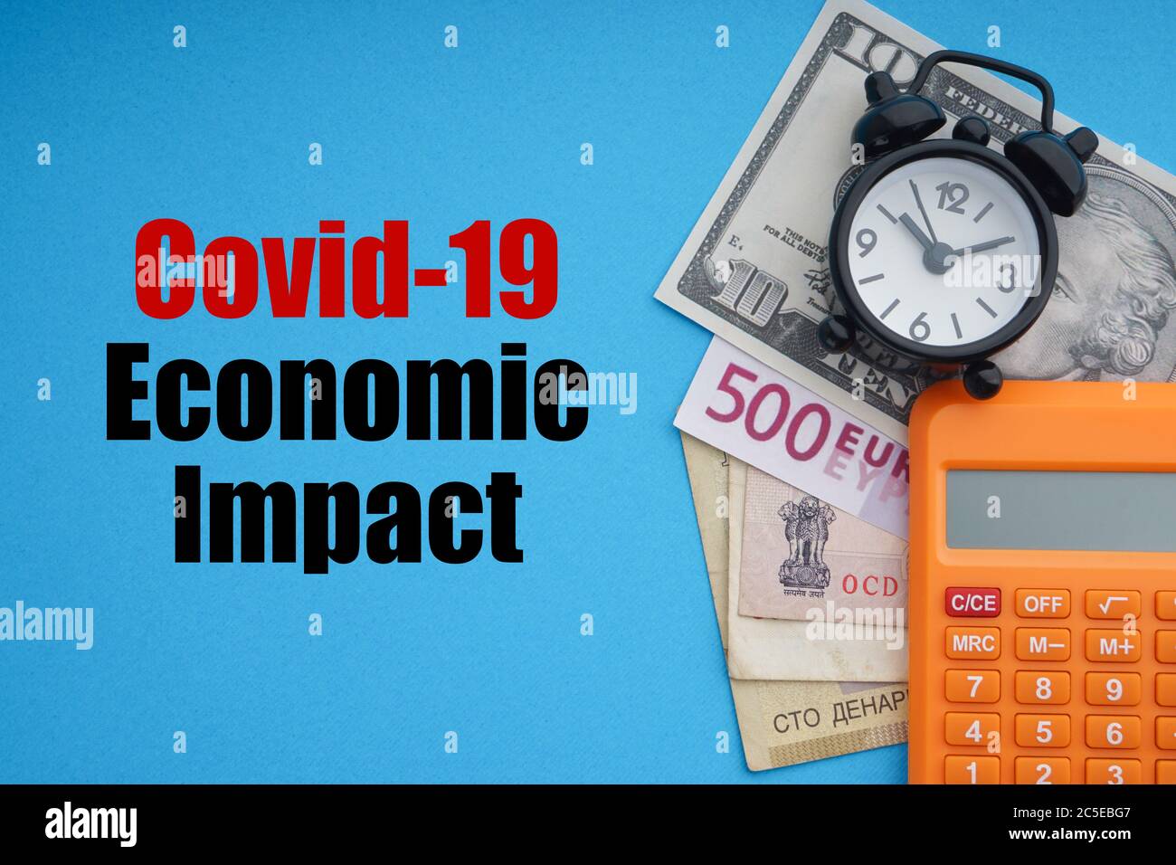 COVID19 testo DI IMPATTO ECONOMICO con sveglia, banconote e calcolatrice su sfondo blu. Coronavirus Covid19 e Business Concept Foto Stock