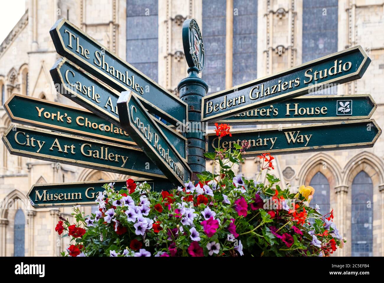 Cartello stradale con indicazioni per diversi punti di riferimento nella città inglese di York - con la Cattedrale di York sullo sfondo Foto Stock