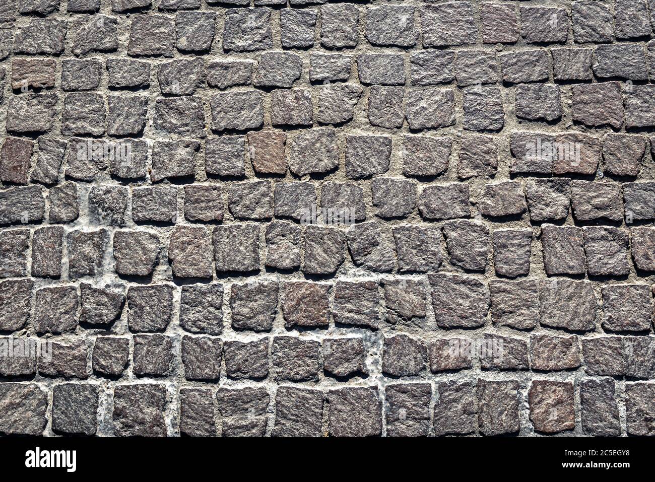 Fondo texture pavimentazione cobblestone. Vista dall'alto della strada in pietra. Dettaglio del marciapiede in granito preso dall'alto. Vecchie strade acciottolate per sfondo. AB Foto Stock