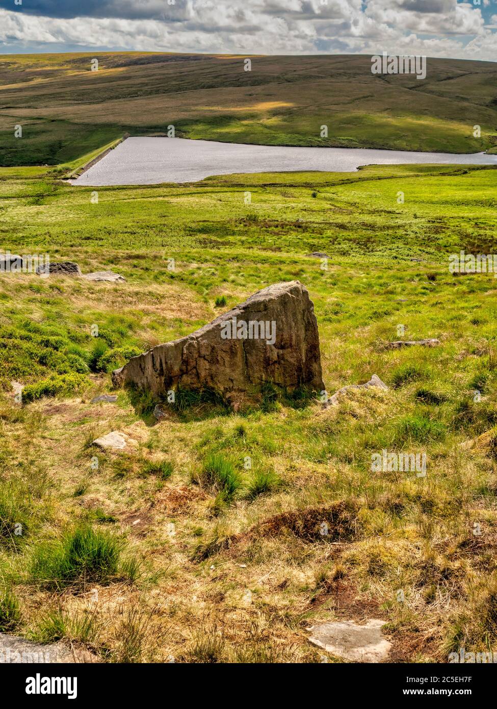 March Haigh Reservoir con grande roccia su Buckstones slack in primo piano. Huddersfield. REGNO UNITO Foto Stock